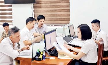 Cán bộ Chi nhánh văn phòng Đăng ký đất đai liên phường, xã Bắc Giang kiểm tra hồ sơ về đất đai của công dân.