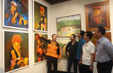 Họa sĩ Hướng Tâm Đường giới thiệu tác phẩm của mình tại triển lãm.