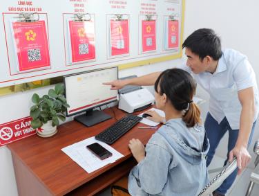 Thành viên Tổ công nghệ số phường Bích Động hướng dẫn người dân thực hiện TTHC trên môi trường điện tử tại bộ phận một cửa.