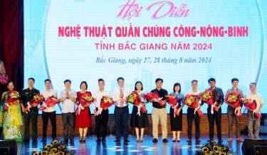Đại diện Ban tổ chức trao cờ lưu niệm cho các đoàn tham gia hội diễn.